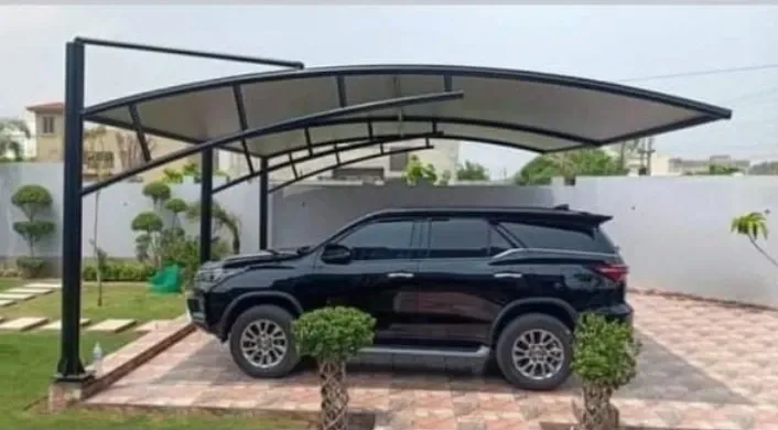 parking-shed-pakistan Curved parking canopy with side supports above a black SUV