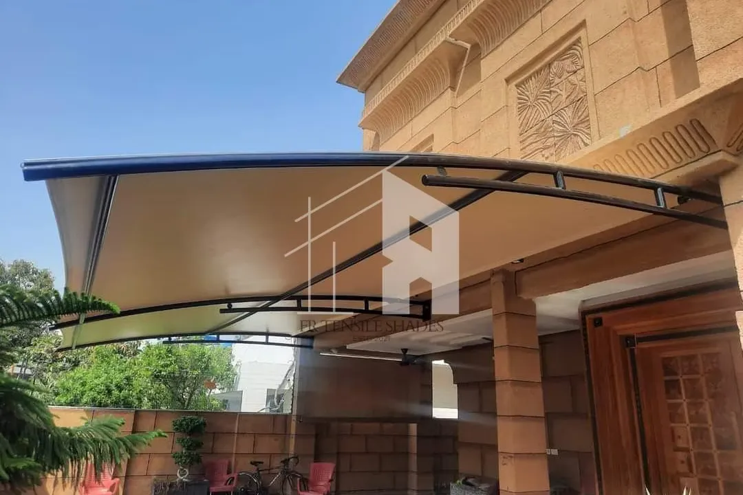 Fabric canopy attached to a house wall above a courtyard